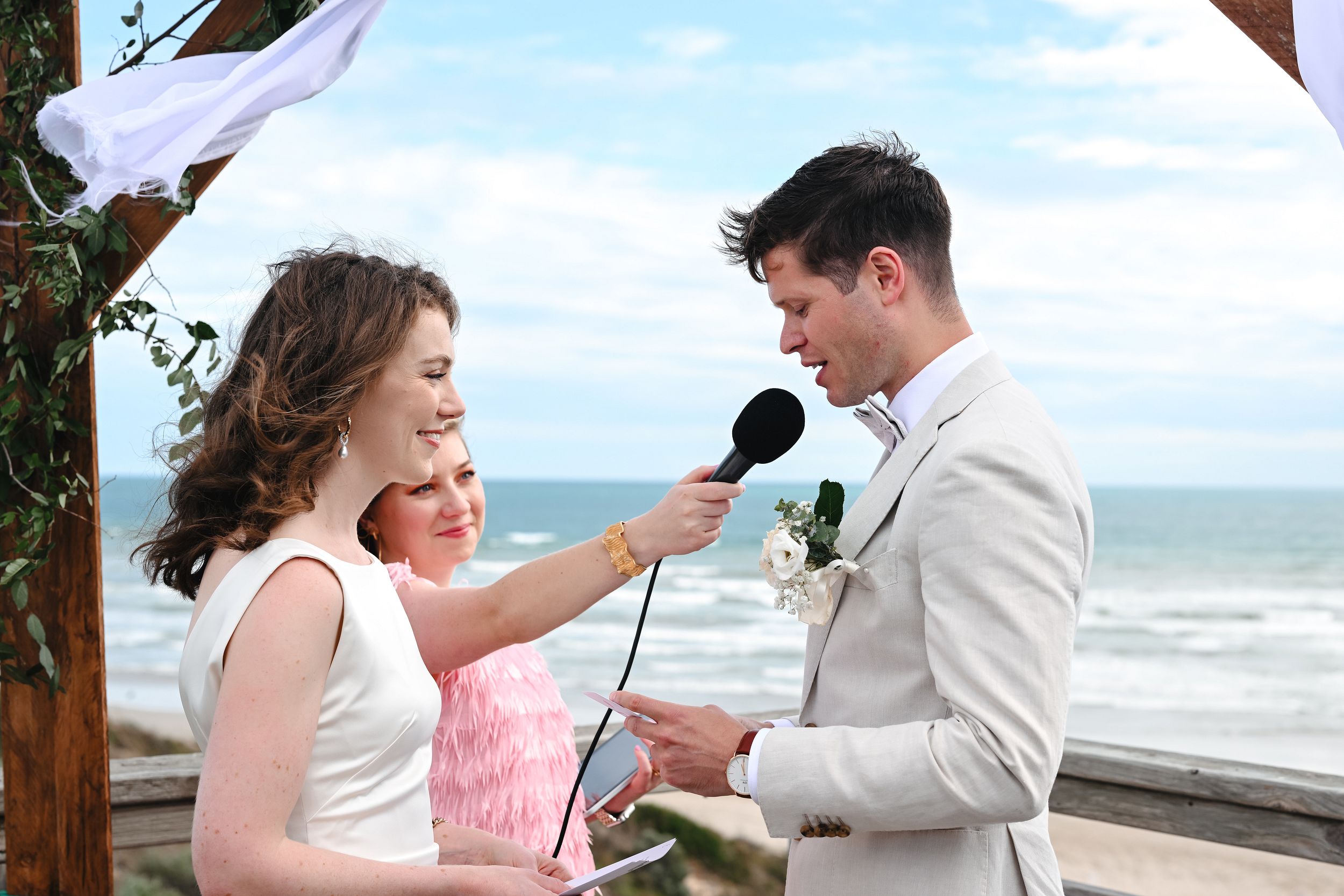 Harriett holding a microphone for groom to say vows